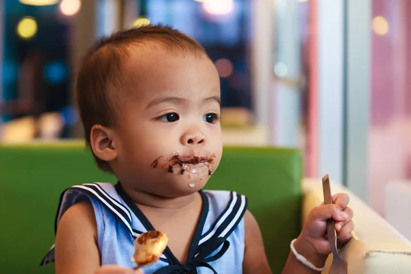 Ásia bebê menina comer chocolate — Fotografia de Stock