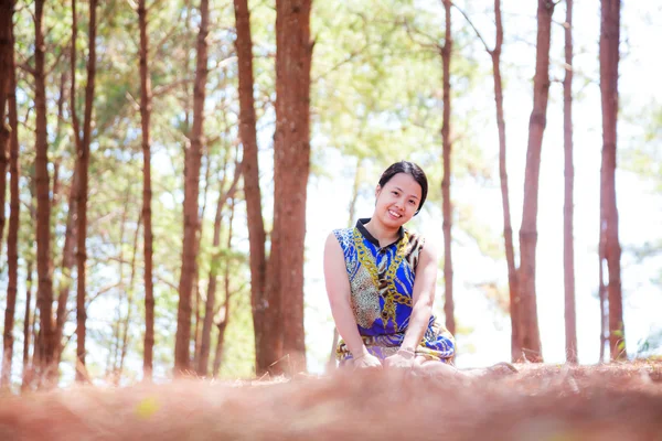 Тайская женщина сидит и улыбается в парке — стоковое фото