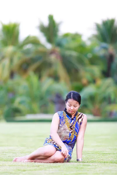 Asian woman sit on ground in park — Stock Photo, Image