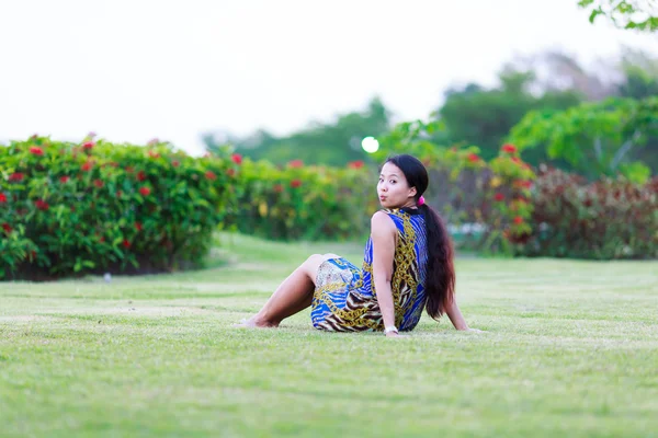 Asian woman sit on ground in park — Stock Photo, Image