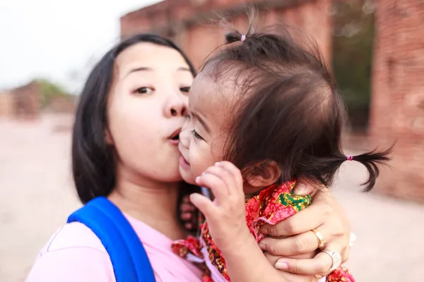 Asian woman kissing her daughter — Stock Photo, Image