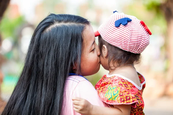 Mujer asiática besando a su hija —  Fotos de Stock