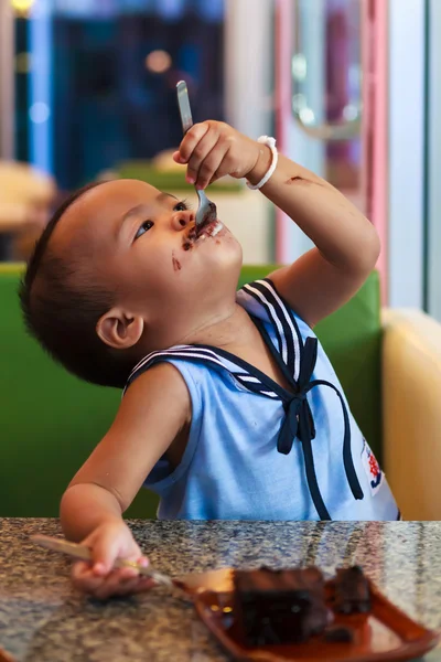 Ásia bebê menina comer chocolate — Fotografia de Stock