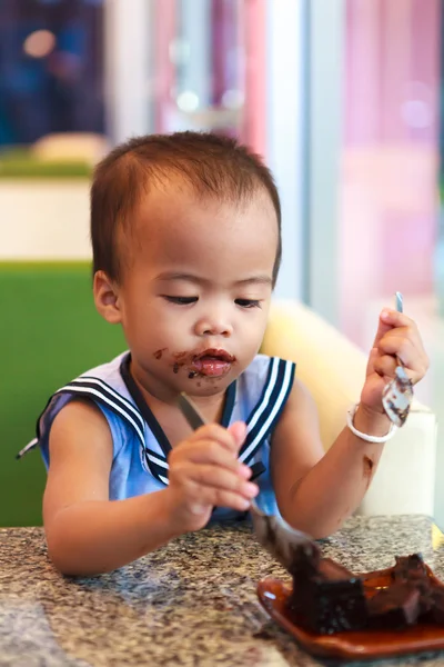 Ásia bebê menina comer chocolate — Fotografia de Stock