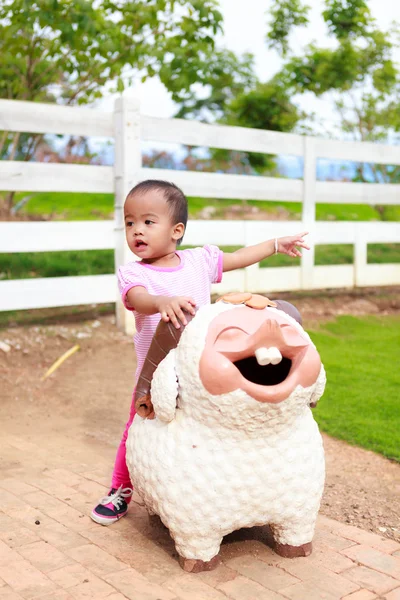 Asian baby girl ride sheep statue — Stock Photo, Image