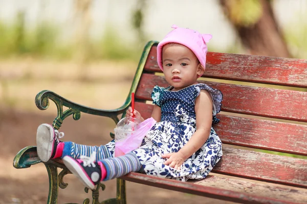 Eenzame Aziatische babymeisje zit met drank — Stockfoto