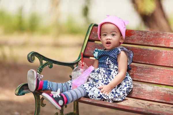 Eenzame Aziatische babymeisje zit met drank — Stockfoto