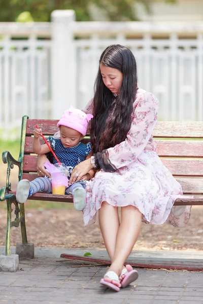 Mãe e filha sentadas no parque — Fotografia de Stock