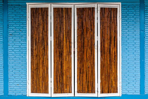 Drzwi bambus na mur z cegły — Zdjęcie stockowe