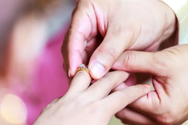 Noivo usando anel no dedo da noiva — Fotografia de Stock