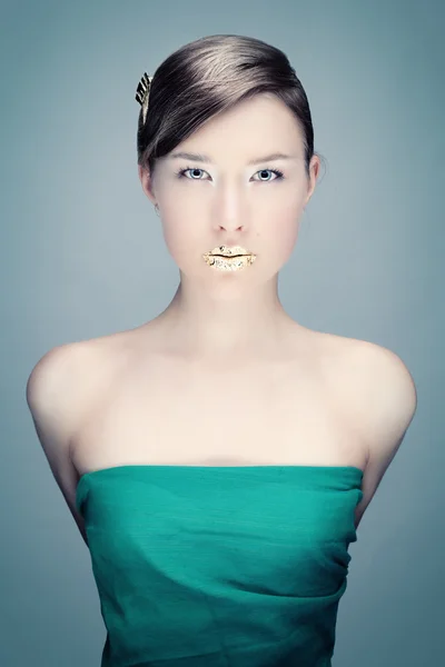 Grünes Porträt einer jungen Frau mit goldenen Lippen — Stockfoto