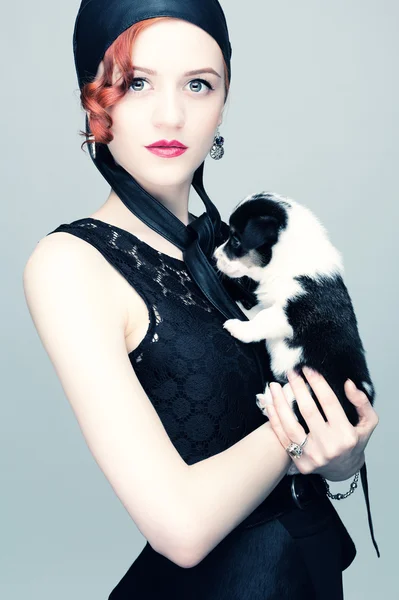 Beautiful woman with a puppy in her arms. — Stock Photo, Image