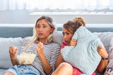 Korkmuş arkadaşlar gecenin bir yarısı evdeki oturma odasındaki bir kanepede oturup televizyon izliyorlar. Kız arkadaşlarla korku filmi gecesi, evde korku filmi izleyen genç kadınlar..
