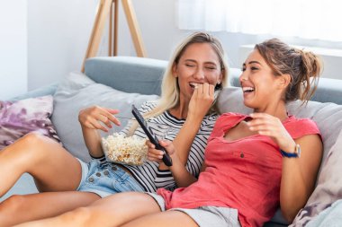 Kız arkadaşım çok komik bir film izliyor ve patlamış mısır yiyor. Gülümseyen genç kadınlar evde televizyon seyrediyor, kadın arkadaşlar zor bir haftadan sonra dinleniyor, mekanı kopyalıyor.
