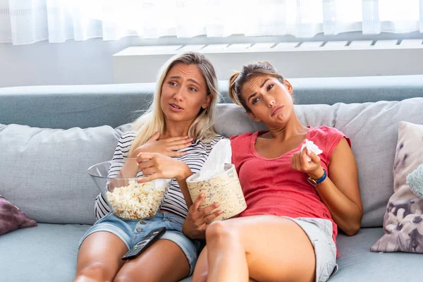 两个最好的朋友在家里看悲伤的电影在床上哭泣着感动 女孩们在电视上拿着爆米花和电视遥控装置 看着电视屏幕上的浪漫电影 睡衣中的女士用纸巾擦拭眼泪 — 图库照片