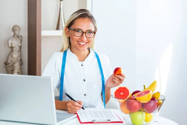 Nutricionista Sorridente Seu Escritório Ela Está Mostrando Vegetais Frutas Saudáveis — Fotografia de Stock