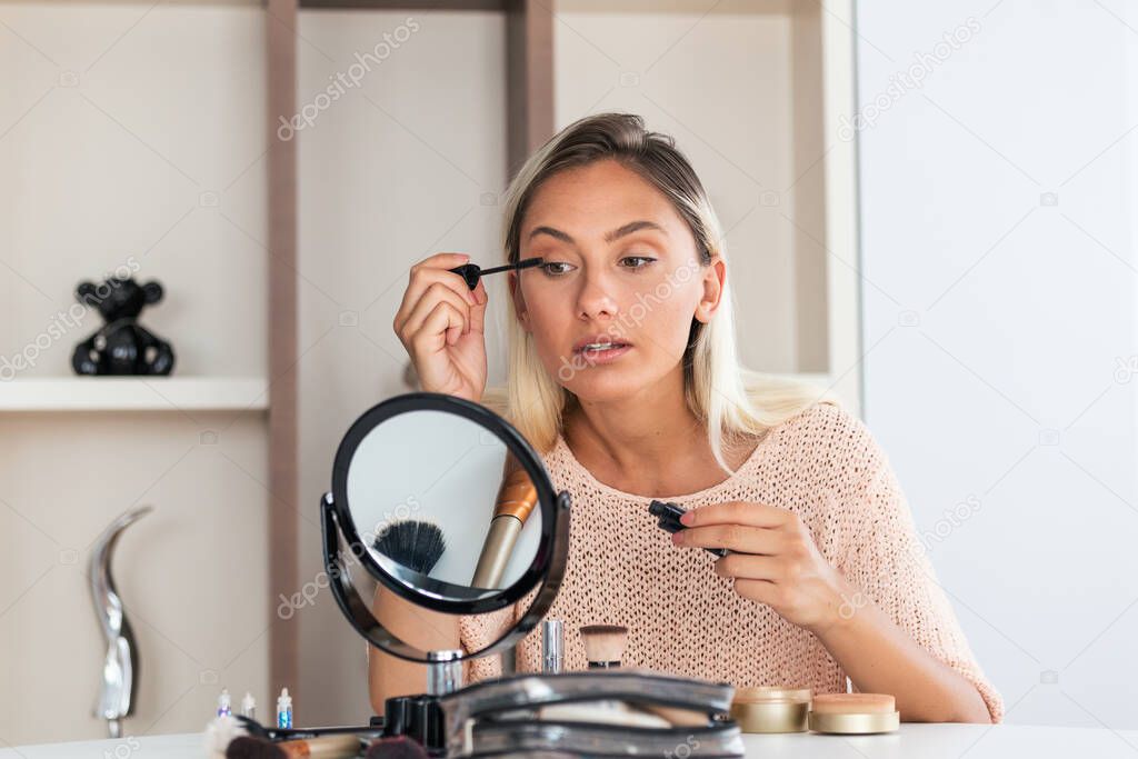 Woman Applying Black Mascara on Eyelashes with Makeup Brush. Beauty Make-up. Portrait Of Beautiful Young Woman Applying Black Mascara On Lashes, Holding Brush In Hand.