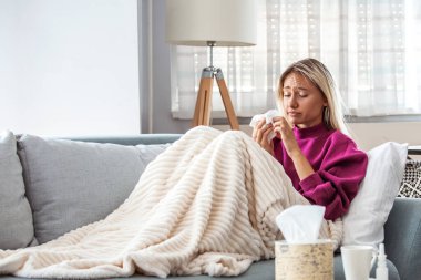 Soğuk ve soğuk algınlığı. Hasta olan, hasta hisseden ve kağıt mendile hapşıran bir kadının portresi. Battaniye Burunlu Güzel Sağlıksız Kız 'a yakın çekim. Coronavirus, covid-19