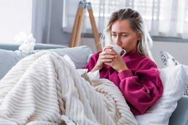 Soğuk ve soğuk algınlığı. Soğuk algınlığına yakalanmış, hasta hisseden ve sıcak içecek içen bir kadının portresi. Battaniye Burunlu Güzel Sağlıksız Kız 'a yakın çekim. Sağlık Hizmetleri Konsepti.