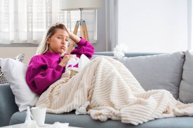 Hasta, çaresiz kadın grip olmuş. Rhinitis, soğuk, hastalık, alerji konsepti. Güzel hasta bir kadının burnu akıyor, burnu mendille sürtüyor. Hapşıran kadın. Esmer mendilin içinde hapşırıyor.