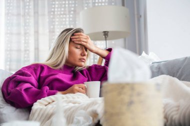 Hasta, çaresiz kadın grip olmuş. Rhinitis, soğuk, hastalık, alerji konsepti. Güzel hasta bir kadının burnu akıyor, burnu mendille sürtüyor. Hapşıran kadın. Esmer mendilin içinde hapşırıyor.