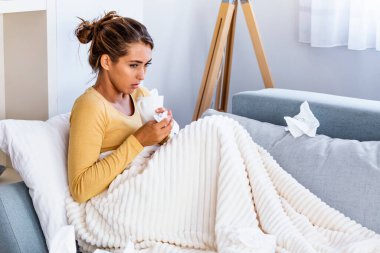 Hasta, çaresiz kadın grip olmuş. Rhinitis, soğuk, hastalık, alerji konsepti. Güzel hasta bir kadının burnu akıyor, burnu mendille sürtüyor. Hapşıran kadın.