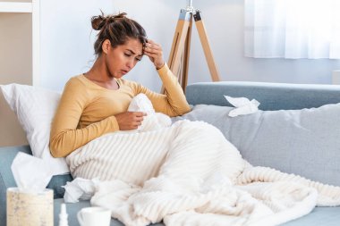 Soğuk ve grip. Hasta kadın portresi üşütmüş, hasta ve kağıt mendil hapşırma. Güzel sağlıksız kız closeup burun silmekten battaniyeye örtülü. Sağlık kavramı. Yüksek çözünürlük