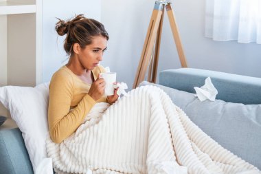 Hasta, çaresiz kadın grip olmuş. Rhinitis, soğuk, hastalık, alerji konsepti. Güzel hasta bir kadının burnu akıyor, burnu mendille sürtüyor. Hapşıran kadın. Esmer mendilin içinde hapşırıyor.