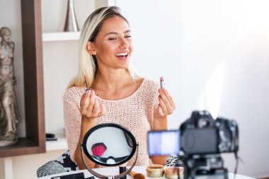 Ünlü blogger. Neşeli kadın vlogger kozmetik ürünler ise video kaydı ve onun güzellik blog için tavsiyeler vererek gösteriyor. Dijital kamera odaklama