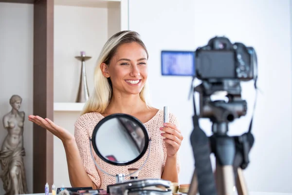 美しい若い女性ブロガーは ソーシャルメディアの概念に自宅のオンラインインフルエンサーで化粧品とVlogビデオを記録します — ストック写真