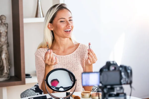 有名なブロガー 陽気な女性ビデオブロガーは ビデオを記録し 彼女の美しさのブログにアドバイスを与えることながら化粧品を見せています デジタル カメラに焦点を当てる — ストック写真