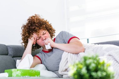 Hasta, çaresiz kadın grip olmuş. Rhinitis, soğuk, hastalık, alerji konsepti. Güzel hasta bir kadının burnu akıyor, burnu mendille sürtüyor. Öksüren kadın..
