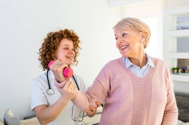 Uzman fizyoterapistle birlikte huzurevinde son sınıf öğrencisi. Yaşlı kadın sağlığına kavuşuyor. fizyoterapist yaşlı bir kadının rehabilitasyonuna yardım ediyor.