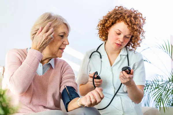 Young Nurse Measuring Blood Pressure Elderly Woman Home Female Nurse — Foto Stock