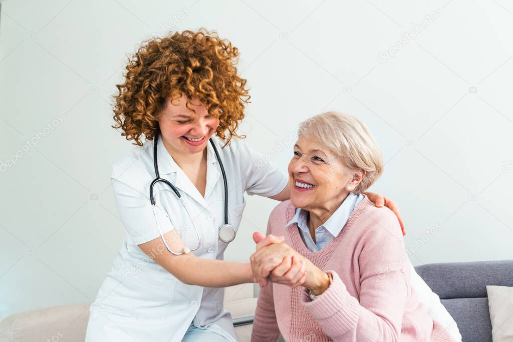 Young caring lovely caregiver and happy ward. Image of caregiver and senior resting in the living room. Smiling caregiver taking care of a happy elderly woman