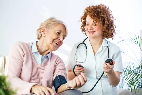 Young Nurse Measuring Blood Pressure Elderly Woman Home Female Nurse — Foto Stock