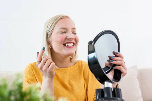 Young Woman Spreading Cream Her Face While Looking Mirror Beauty —  Fotos de Stock