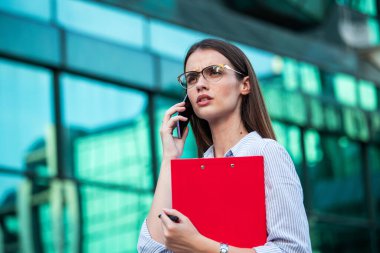 Businesswoman in formal wear having trouble with contracts on clipboard. Businesswoman angry abount about paperwork failure at workplace, executives having conflict over responsibility for bad work results