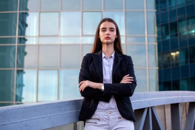 Çapraz kollu bir iş kadını. Ofiste büyük bir pencerenin yanında duran kendine güvenen modern iş kadını..