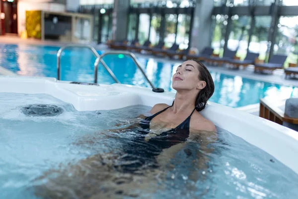 Excited Female Enjoys While Splashing Warm Water Spa Procedure Whirlpool — Zdjęcie stockowe