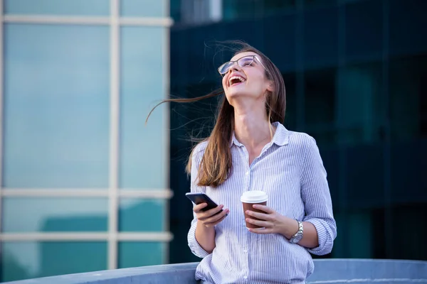 Mobil Akıllı Telefonda Mutlu Gülümseyen Kadını Arka Planda Ofis Binaları — Stok fotoğraf