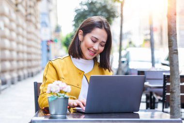 Güzel genç Asyalı kız computer.flare ışık yolu ile internet'e bağlanan bir laptop.female serbest meslek ile bir kahve dükkanında çalışan