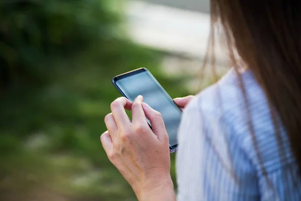 Close up of women's hands holding cell telephone with blank copy space scree for your advertising text message or promotional content.