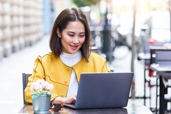 드레스를 아시아 사업가 카페에 앉아서 노트북으로 있습니다 위에는 노트북 스마트폰 — 스톡 사진