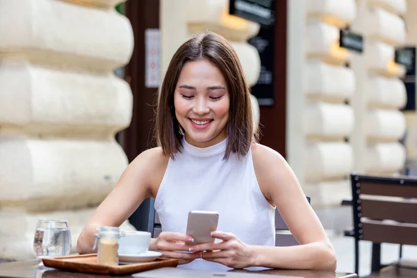 Smiling Woman Drinking Coffee Using Her Mobile Phone Satisfied Female — Stockfoto
