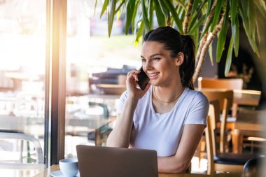 Genç ve çekici bir kadın cep telefonuyla arıyor. Boş zamanlarında kafede tek başına oturuyor. Güzel gülüşlü çekici bir kadın barda dinlenirken cep telefonuyla konuşuyor.