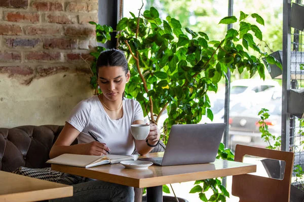 Kafede bir fincan kahve içen bir kadın. Parlak güneşli bir sabah. Kahve içen ve kahve molasında internette sörf yapan muhteşem bir kadın. Sabah kahvesi benim günlük rutinim.