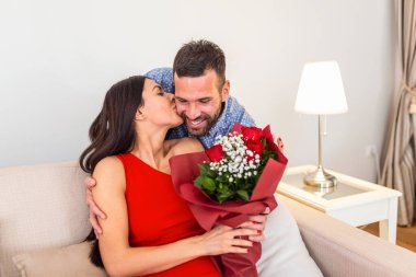 Evdeki güzel genç çift. Sevgililer Günü 'nü kırmızı güllerle kutlarken sarılıp, öpüşüp, eğleniyoruz.