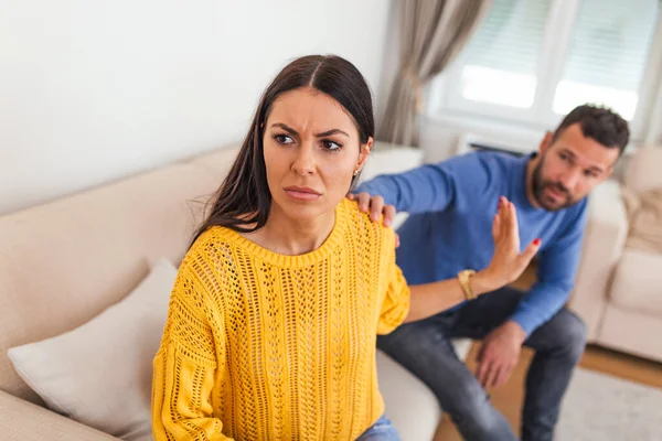 Young man begging his girlfriend to forgive him. Husband asking his pretty wife for forgiveness after conflict. Angry woman refusing apologies from her man