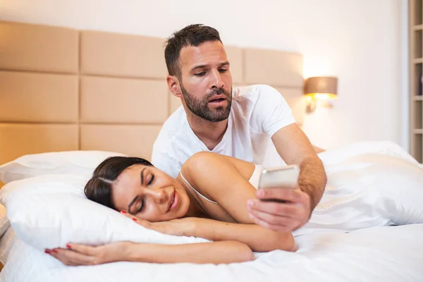 Geloso Marito Spiare Telefono Del Suo Partner Mentre Lei Dorme — Foto Stock